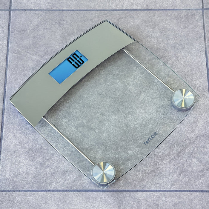 Digital glass bathroom scale with stainless steel accents and a blue digital display