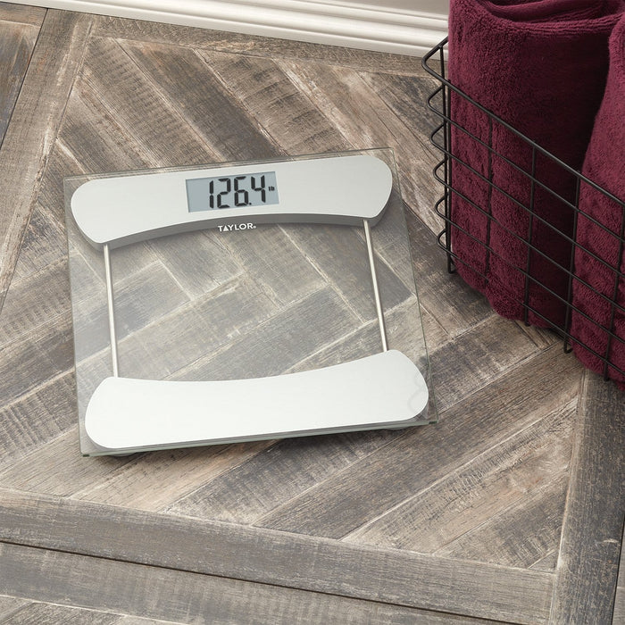 Taylor digital glass bathroom scale with a curved top panel and metal legs showing 126.4 lb.