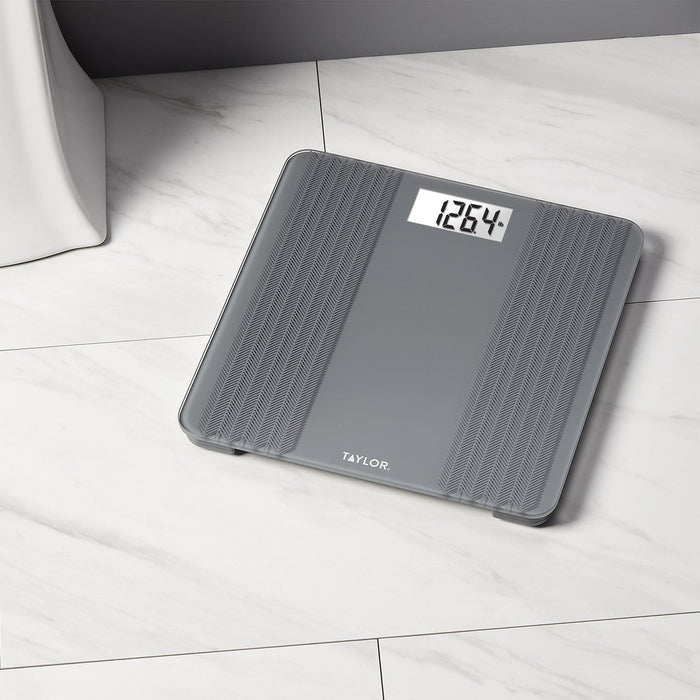 Gray digital glass scale with a textured herringbone pattern on the sides and a digital readout on marble floor