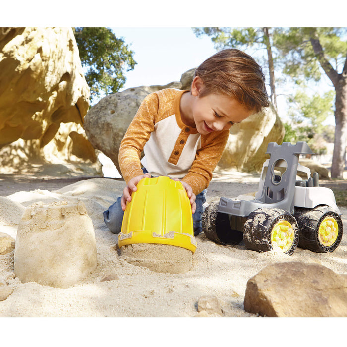 Boy using bucket as sand mold