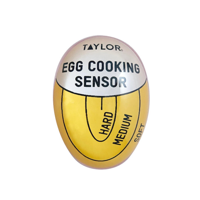 Egg shaped timer bearing the Taylor logo and EGG COOKING SENSOR label on a yellow surface