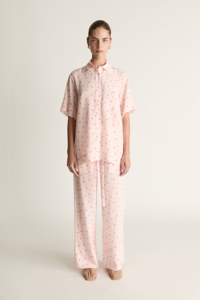 Person wearing pink floral short sleeve shirt and pants set