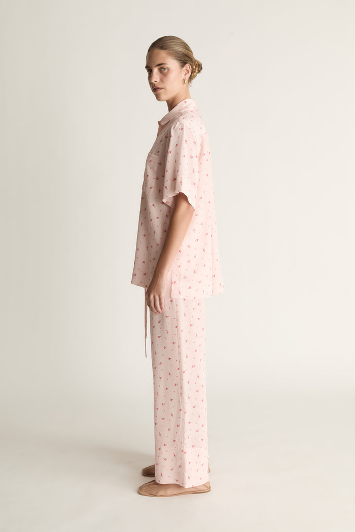 Person wearing pink floral short sleeve shirt and pants set
