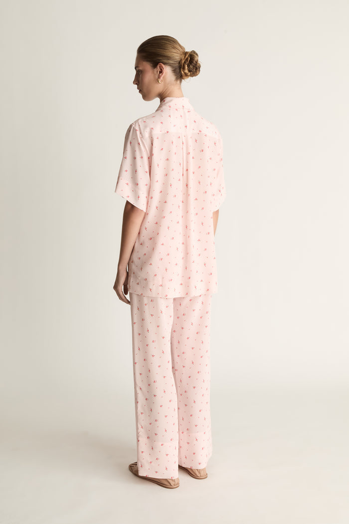 Person wearing pink floral short sleeve shirt and pants set