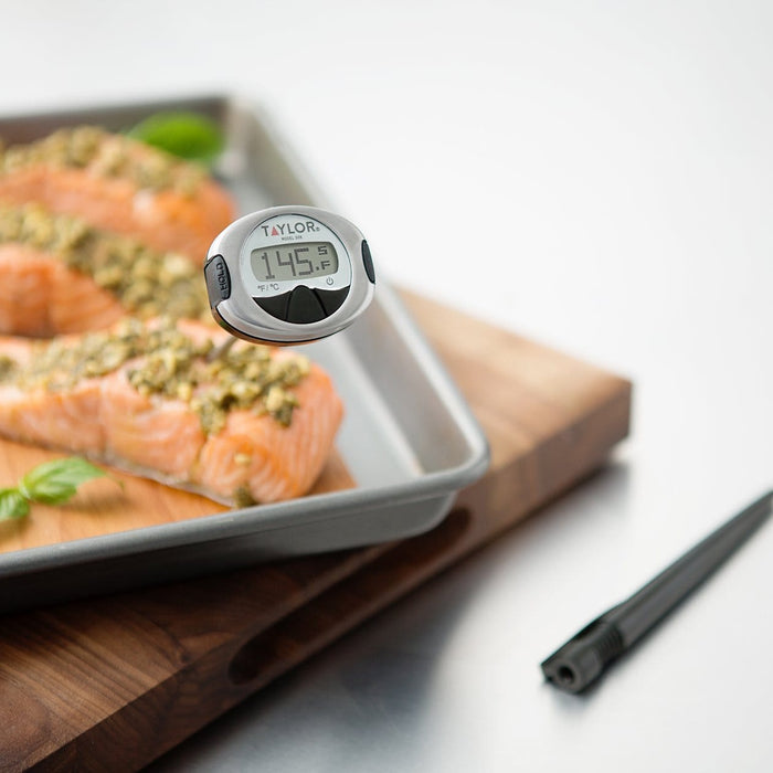 Close-up of Taylor PRO digital thermometer head on its metal probe over seasoned salmon