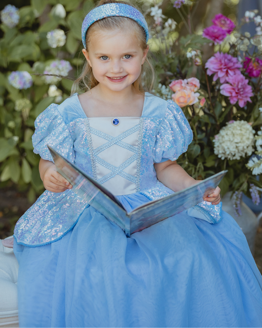 Girl wearing a blue sequin princess dress with puff sleeves and a full tulle skirt