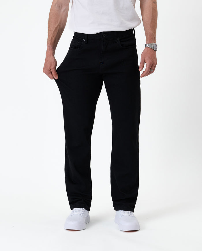 The Jeans Classic Straight Fit in jet black — showing the stretch of the denim fabric