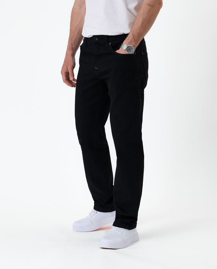 The Jeans Classic Straight Fit in jet black — front view worn with white sneakers