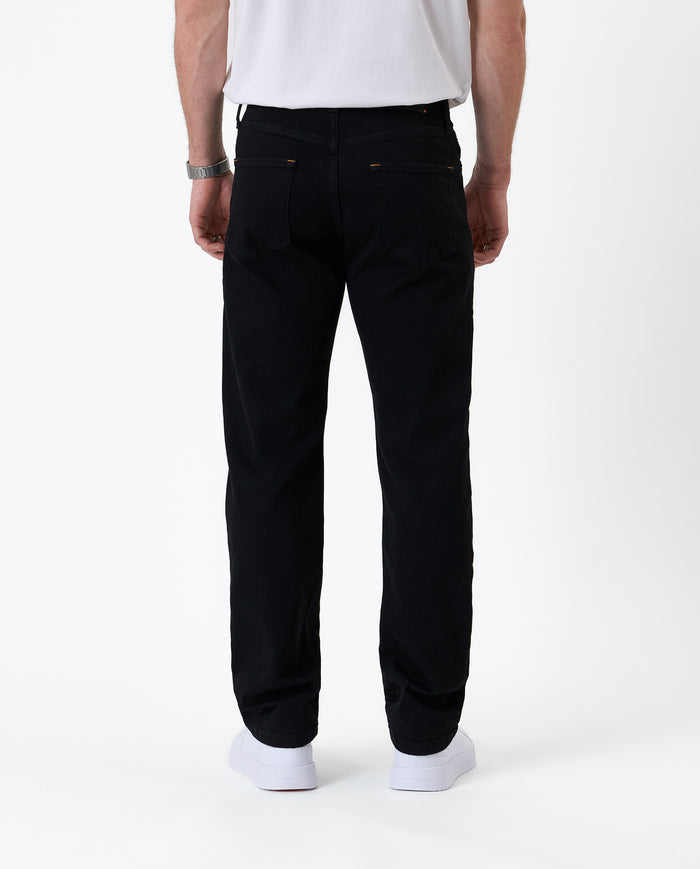 The Jeans Classic Straight Fit in Jet Black — back view worn with white sneakers
