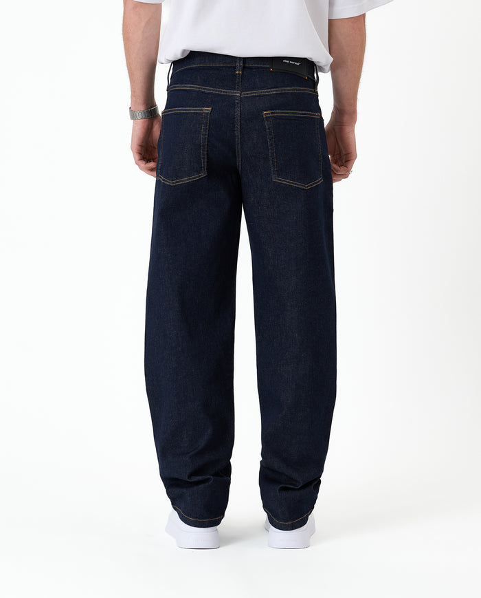 The Jeans Relaxed Straight Fit in rinse wash — back view with the black C'est normal rubber patch