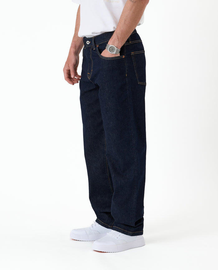 The Jeans Relaxed Straight Fit in rinse wash — side view with hand in pocket