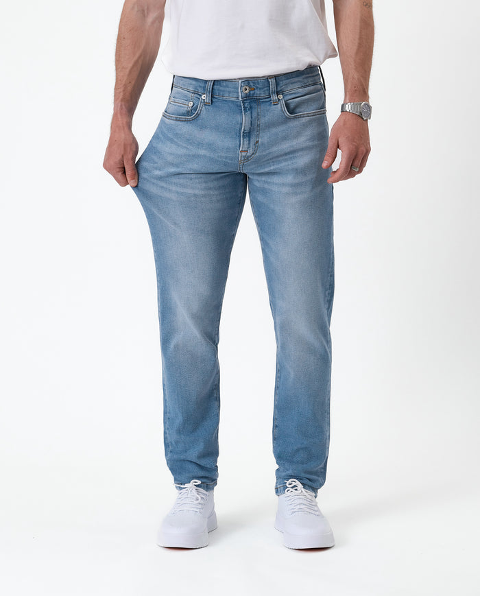 The Jeans Slim Fit in Light Midwash — showing the stretch of the Motion Fabric
