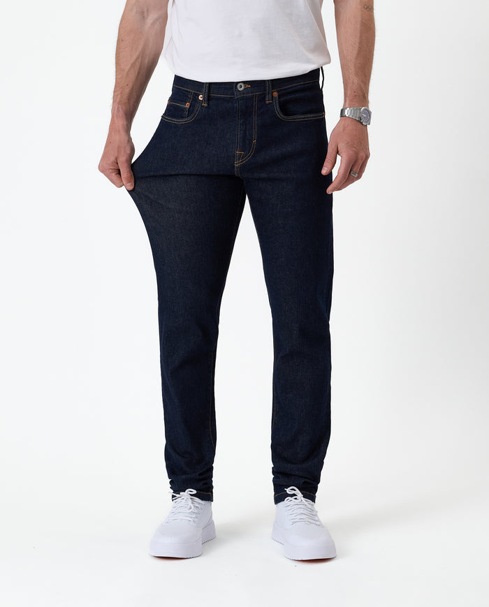 The Jeans Slim Fit in Rinse Wash — demonstrating the stretch of the Motion Fabric