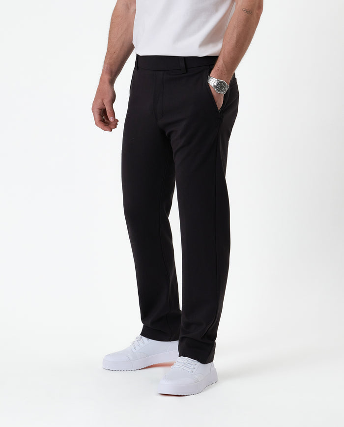 The Proper Pant Regular Fit in black — side view worn with white sneakers
