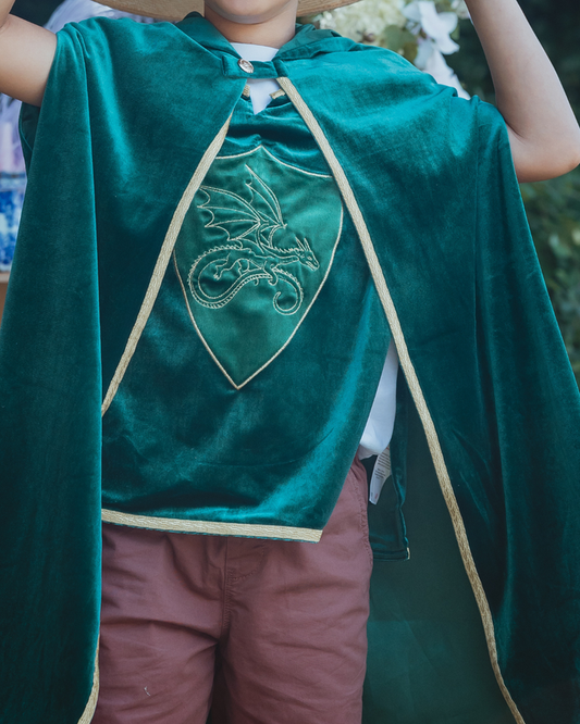 Child wearing a green velvet knight's tabard with an embroidered dragon