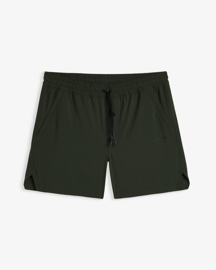 A front view of The Shorts in khaki, laid flat on a white background. The image highlights the elasticated waistband with a black drawstring, side pockets, notched hem, and a subtle c'est normal logo on the left leg.