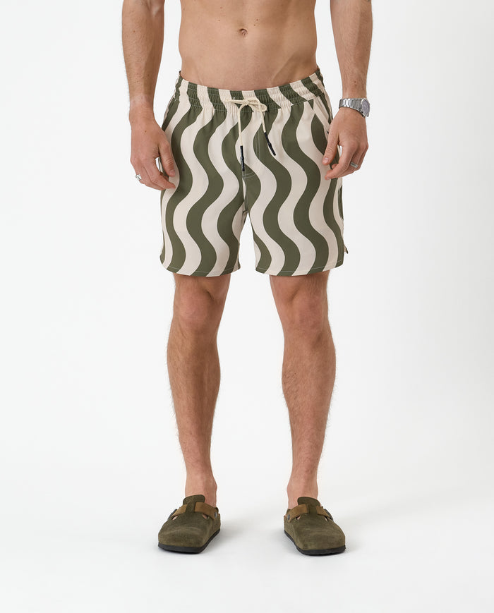 The Shorts in olive curl stripe — featuring a wavy pattern and styled with green clogs