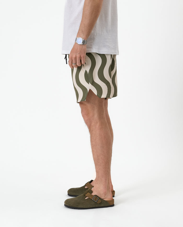 The Shorts in olive curl stripe — side profile showing the notched hem and wavy pattern