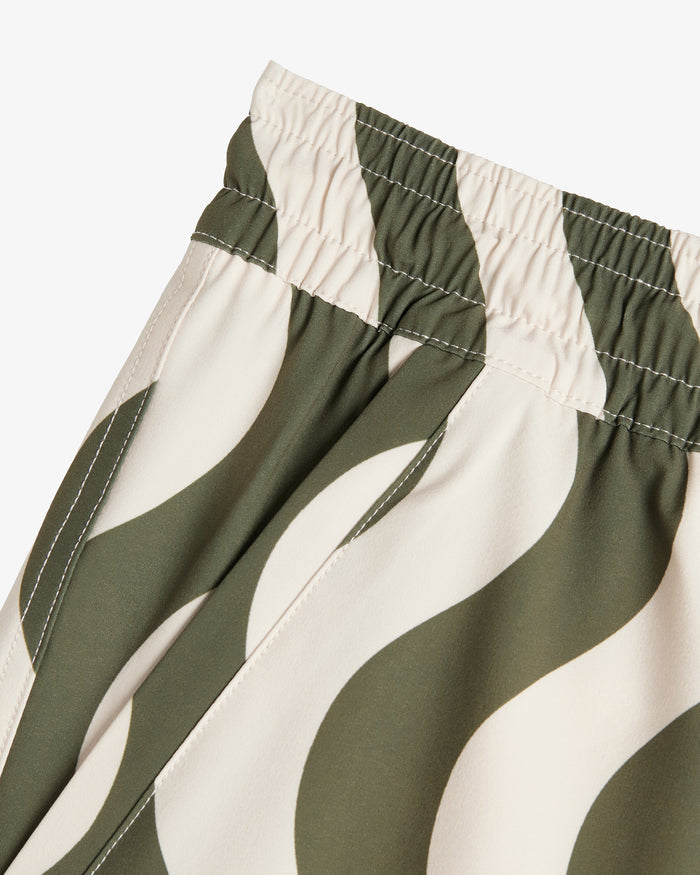 A detailed close-up of The Shorts in Olive Curl Stripe, focusing on the elasticated waistband, side seam, and the wavy two-tone fabric pattern.