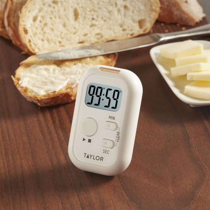 Taylor timer with light sound and vibration on a wooden table beside slices of bread and butter