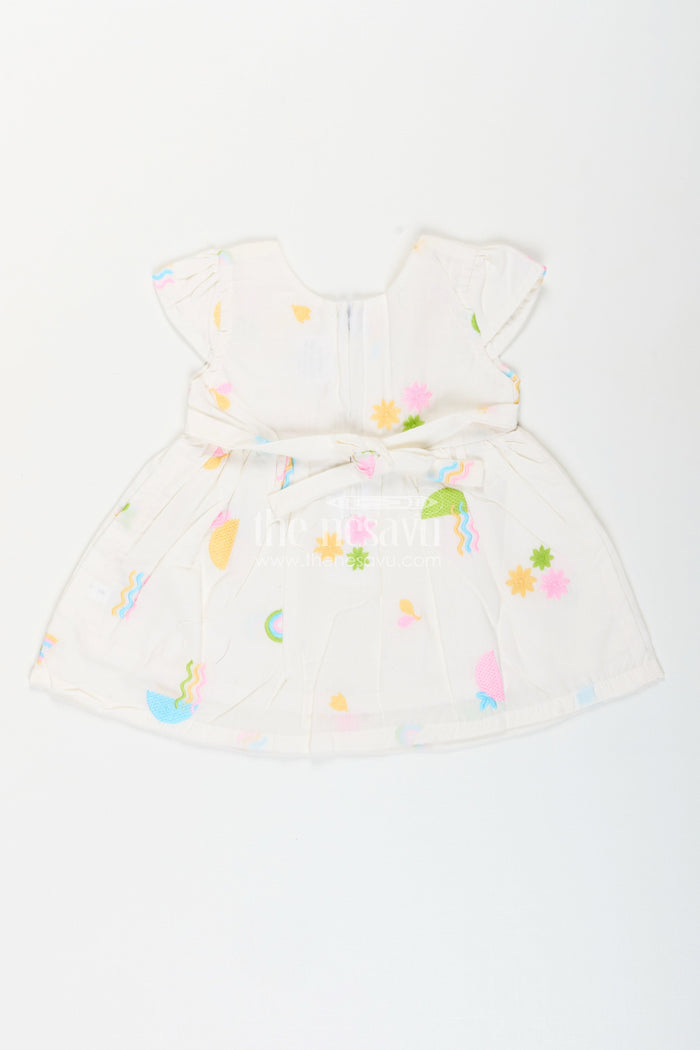 The Nesavu Baby Cotton Frocks White baby girl frock with pastel embroidery for everyday wear Nesavu Nesavu white baby girl frock with pastel rainbow embroidery and flutter sleeves for casual wear