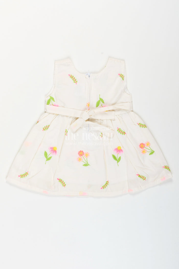 The Nesavu Baby Cotton Frocks White frock for baby girls with floral embroidery and waist bow Nesavu Nesavu white cotton frock for baby girls with bow and floral embroidery for casual dressing